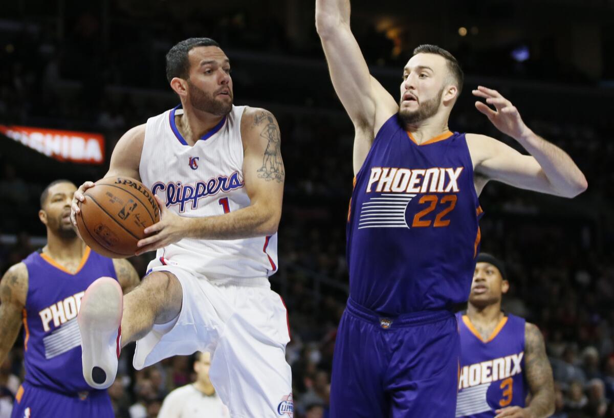 Jordan Farmar passes the ball around Phoenix center Miles Plumlee during the first half of the Clippers' 120-107 win Nov. 15 over the Suns.