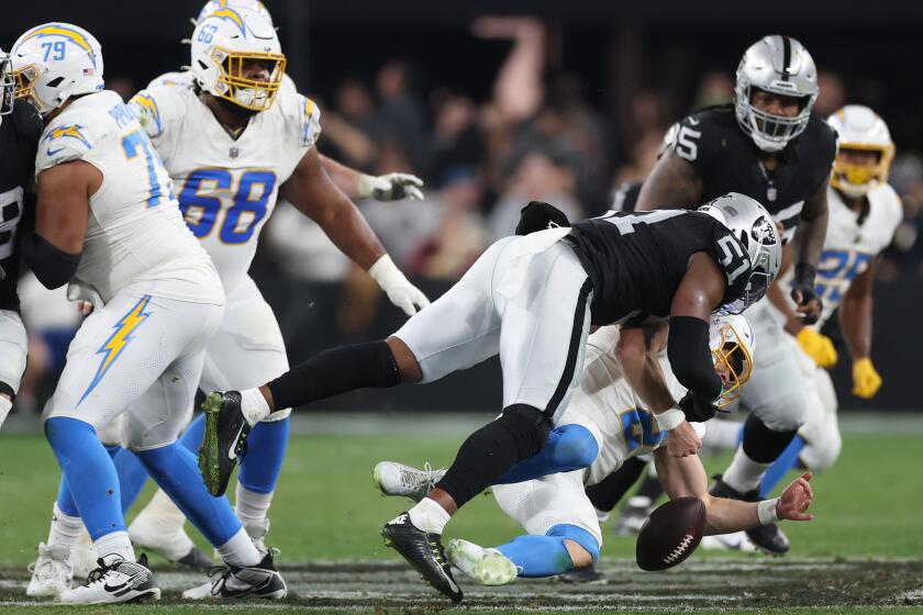 LAS VEGAS, NEVADA - DECEMBER 14: Defensive end Malcolm Koonce #51 of the Las Vegas Raiders forces a fumble on quarterback Easton Stick #2 of the Los Angeles Chargers during the third quarter at Allegiant Stadium on December 14, 2023 in Las Vegas, Nevada. (Photo by Sean M. Haffey/Getty Images)