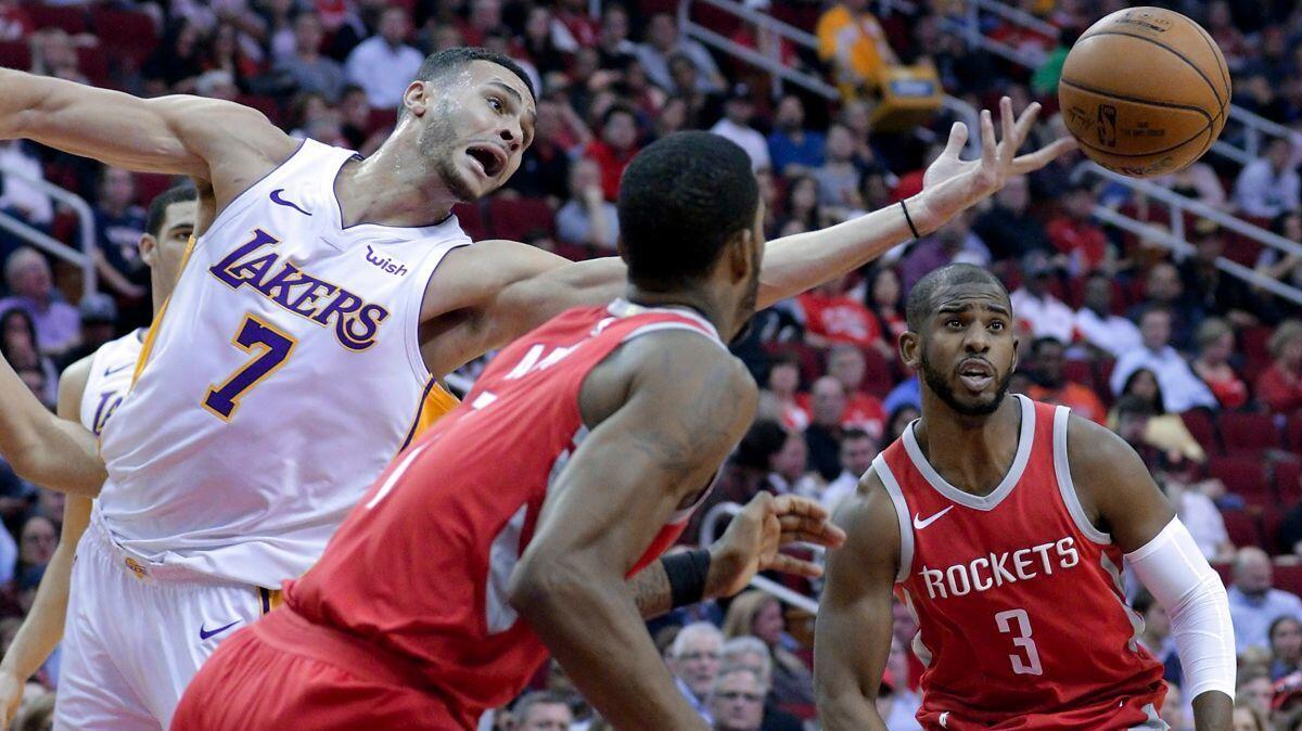 Lakers forward Larry Nance Jr. (7) reaches for a rebound between Houston Rockets forward Trevor Ariza (1) and guard Chris Paul (3) in the first half on Wednesday.