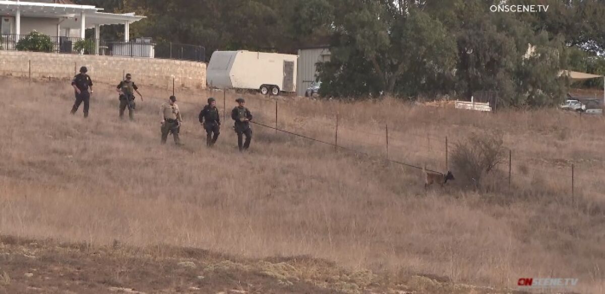 Sheriff's deputies use a dog to help search the area near where a 46-year-old man fatally shot Thursday in Ramona.