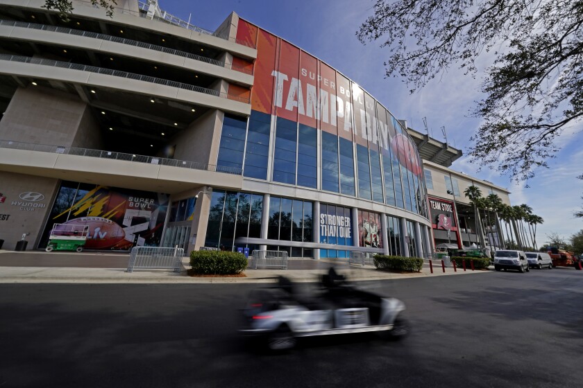 Workers drive past Raymond James Stadium ahead of Super Bowl 55 Thursday, Feb. 4, 2021, in Tampa, Fla. The city is hosting Sunday's Super Bowl football game between the Tampa Bay Buccaneers and the Kansas City Chiefs. (AP Photo/Charlie Riedel)