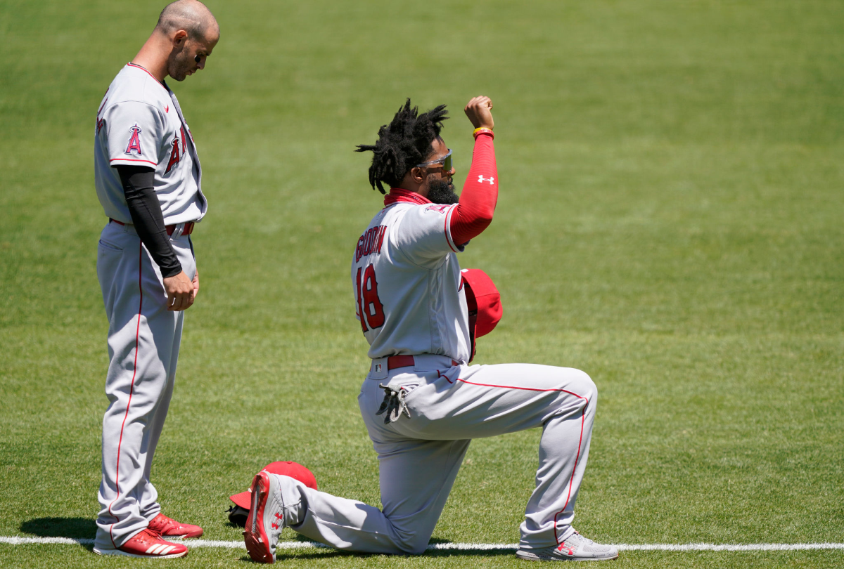 Angels outfielder Brian Goodwin takes a knee and raises his fist during the playing of the national anthem.