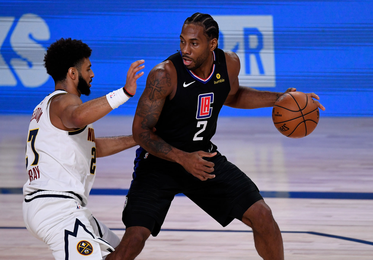 Kawhi Leonard #2 of the LA Clippers drives the ball against Jamal Murray.