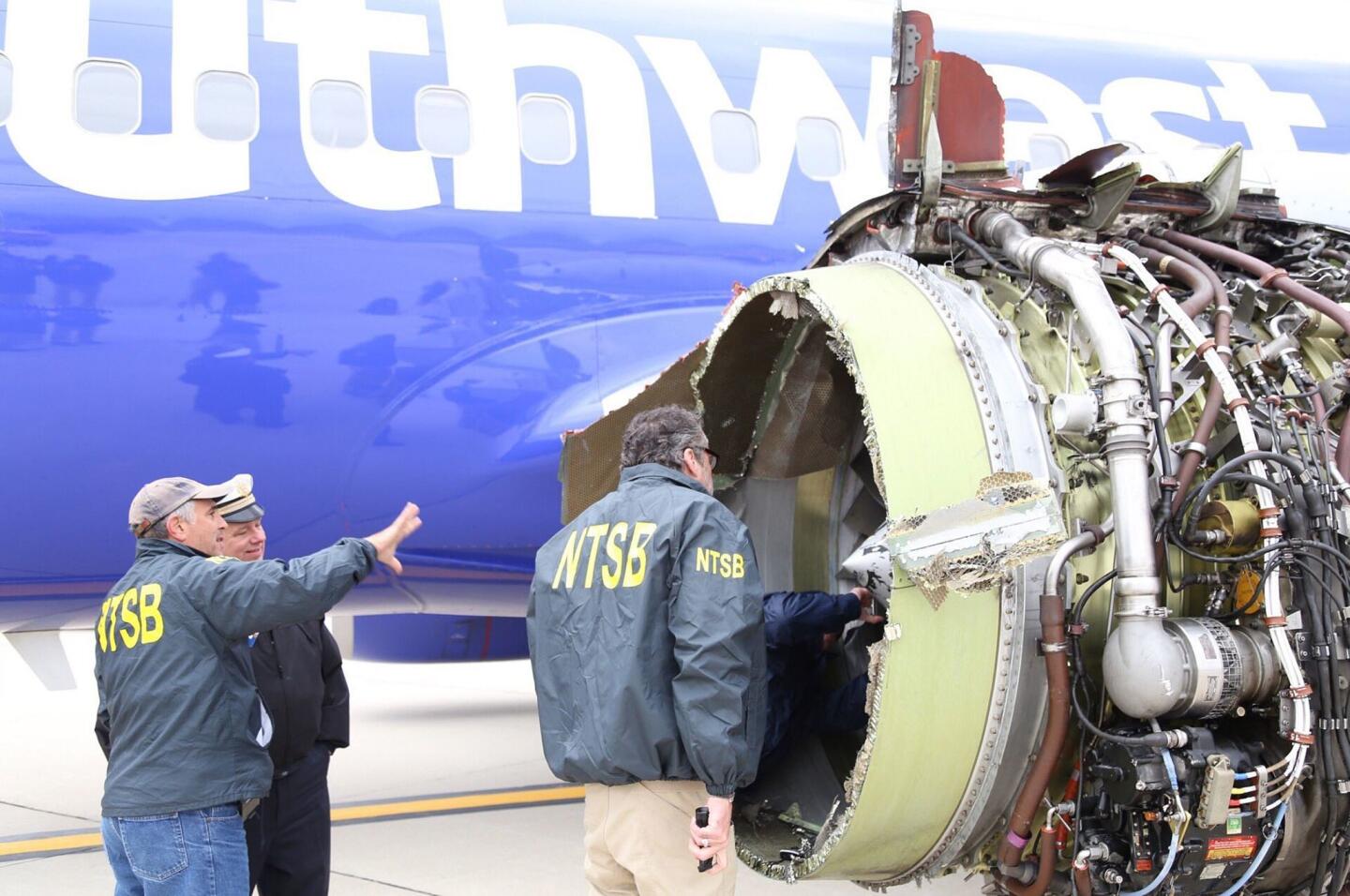 A handout photo made available by the National Transportation Safety Board shows investigators examining the damaged engine of Southwest Airlines flight 1380 which was en route from LaGuardia Airport in New York City to Love Field in Dallas, Texas when it exploded in flight sending shrapnel into the fuselage, breaking a window and causing the plane to make an emergency landing at Philadelphia Airport in Philadelphia, Pennsylvania, USA, 17 April 2018.