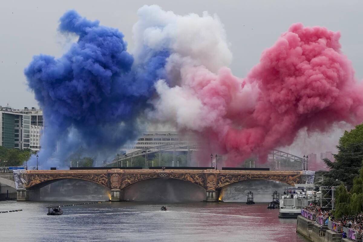 Ceremonial smoke of the French flag appear over the Seine River in Paris, during the opening ceremony of the 2024 Olympics.