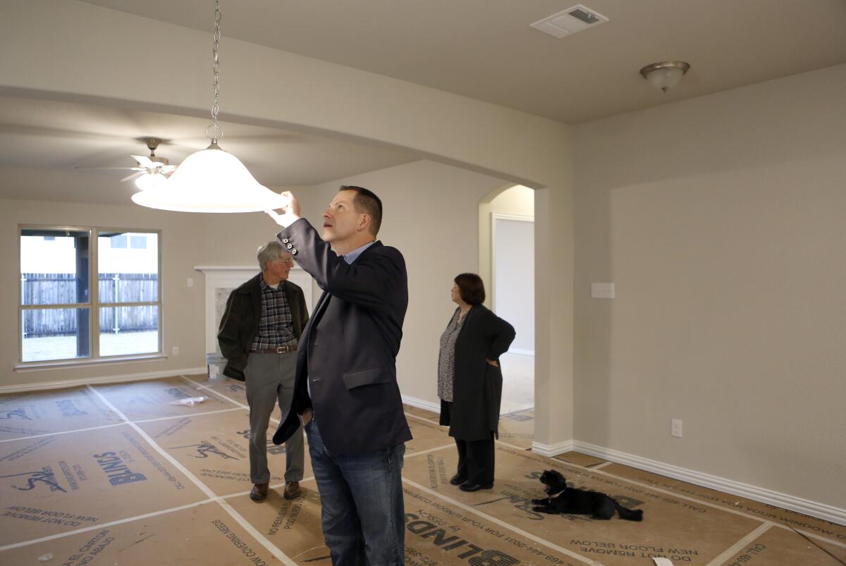 Conservative Move Texas agent Derek Baker shows Judy and Richard Stark, who moved from Modesto, their new home in McKinney, Texas, on Oct. 29.