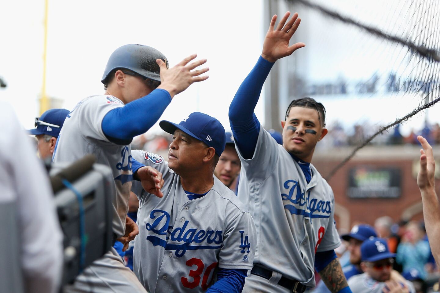 SAN FRANCISCO, CA - SEPTEMBER 29: Enrique Hernandez #14 of the Los Angeles Dodgers is congratulated by manager Dave Roberts #30 and teammate Manny Machado #8 after scoring on single hit by Chris Taylor #3 of the Los Angeles Dodgers during the ninth inning against the San Francisco Giants at AT&T Park on September 29, 2018 in San Francisco, California. (Photo by Lachlan Cunningham/Getty Images) ** OUTS - ELSENT, FPG, CM - OUTS * NM, PH, VA if sourced by CT, LA or MoD **