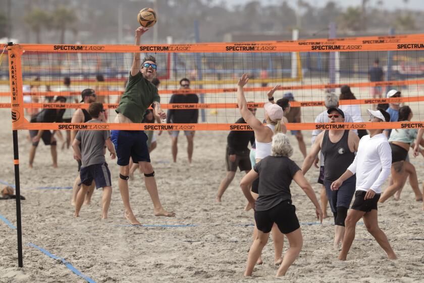 SAN DIEGO, CA - MAY 25, 2024: Michael Mielke hits the ball as he and other people play beach volleyball through an online meetup at Mission Beach in San Diego on Saturday, May 25, 2024.