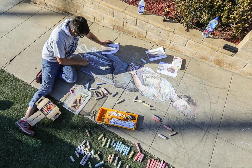 OB resident Erick Toussaint works on a one of his chalk art creations outside his Ocean Beach home on July 24, 2020 in San Diego, California.