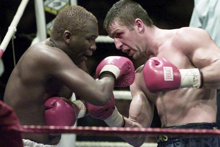 FILE — Defending champion Eric Lucas, right, serves an uppercut to South Africa's Dingaan Thobela, left, during the WBC super middleweight championship on Nov. 30, 2001 in Montreal, Canada. Thobela, a two-weight world champion known as "The Rose of Soweto," has died. He was 57. (AP Photo/Paul Chiasson, File)