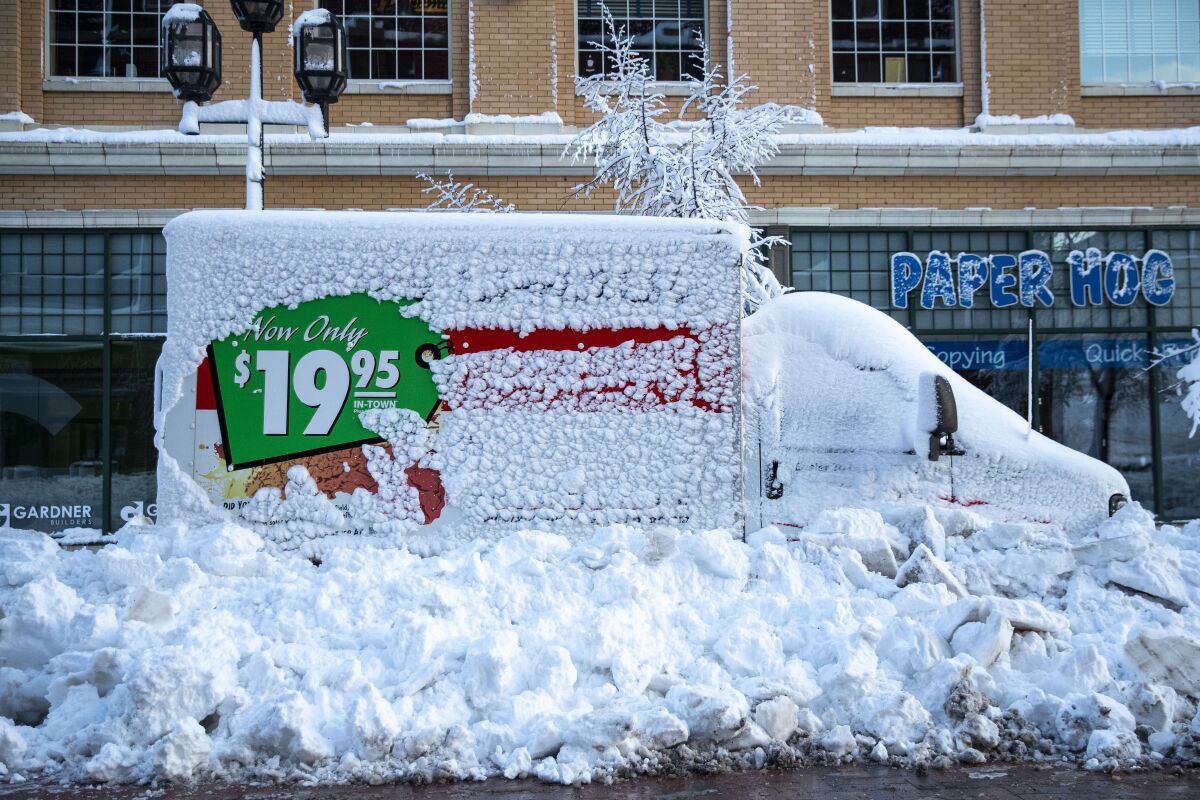 A U-Haul truck sits snowed in by plows on Sunday along First Street in downtown Duluth, Minn.