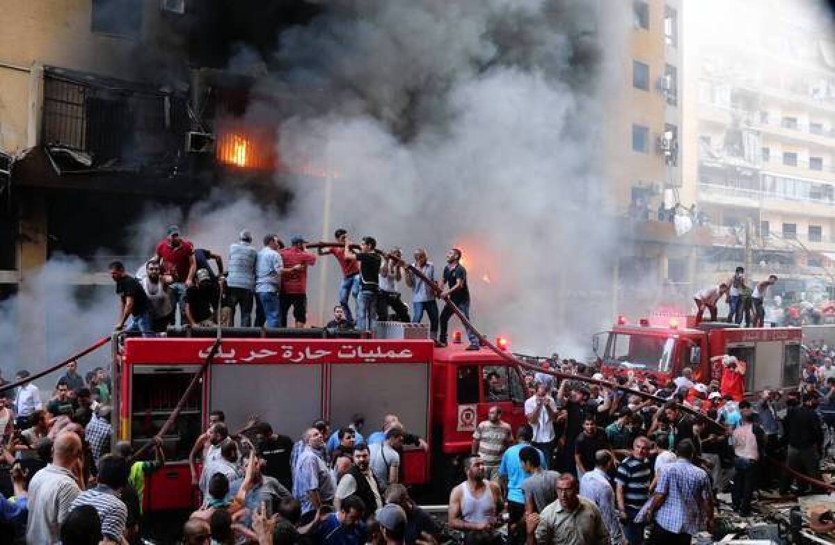 Lebanese civilians and emergency personnel gather at the site of a car bombing in southern Beirut. Some fear the attack is related to the war in neighboring Syria.