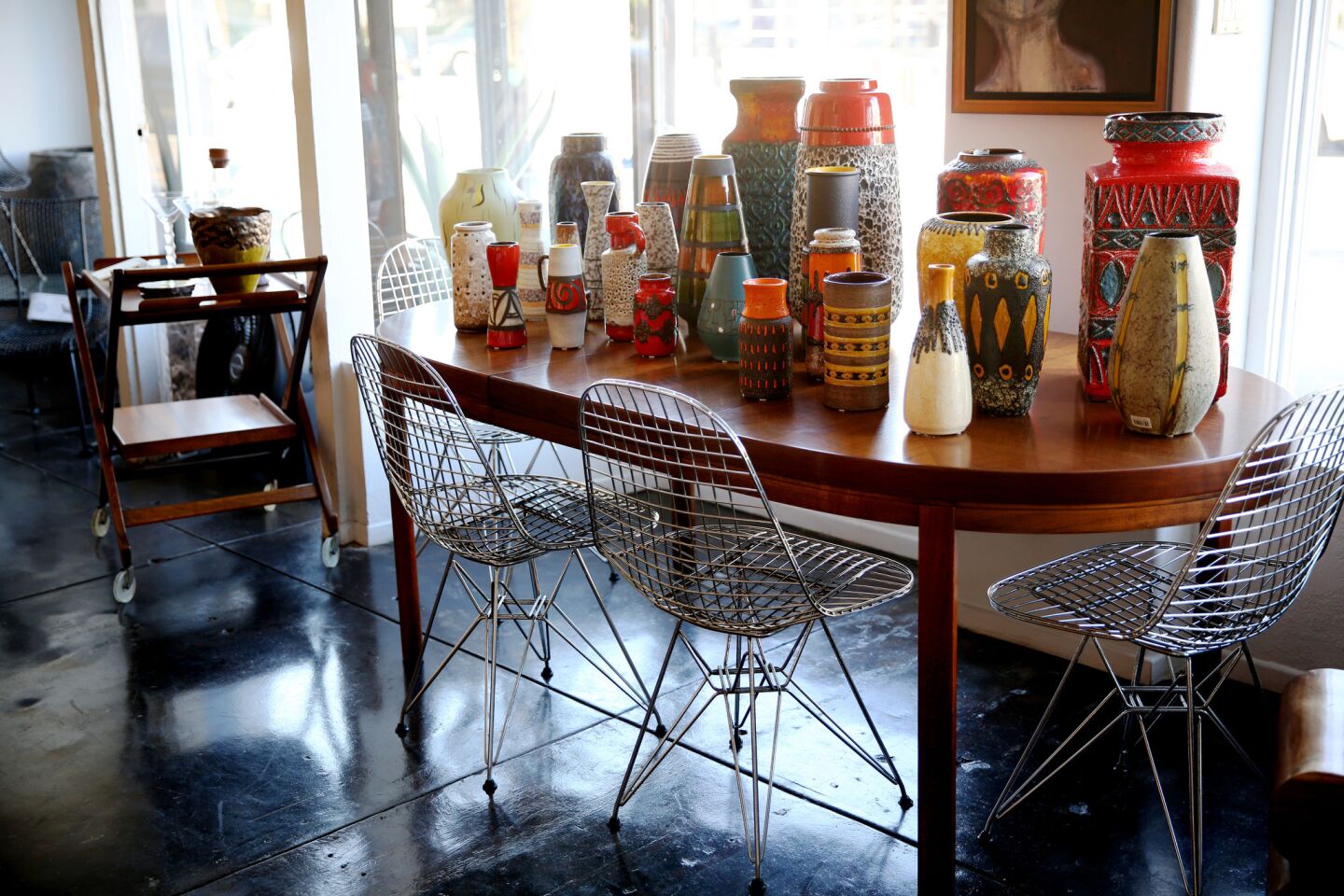 West German pottery decorates a tabletop at Trebor/Nevets in Long Beach. A set of four Eames Eiffel Tower chairs by Herman Miller sit around the table.