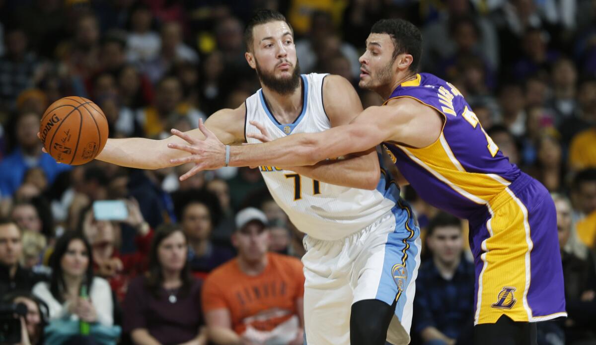 Denver Nuggets center Joffrey Lauvergne, left, looks to pass the ball as Los Angeles Lakers forward Larry Nance Jr. defends in the first half on Tuesday.