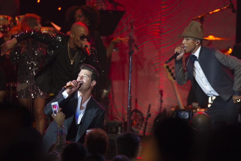 Robin Thicke, front, performs on stage with T.I., left, and Pharrell Williams in 2014 in Beverly Hills.