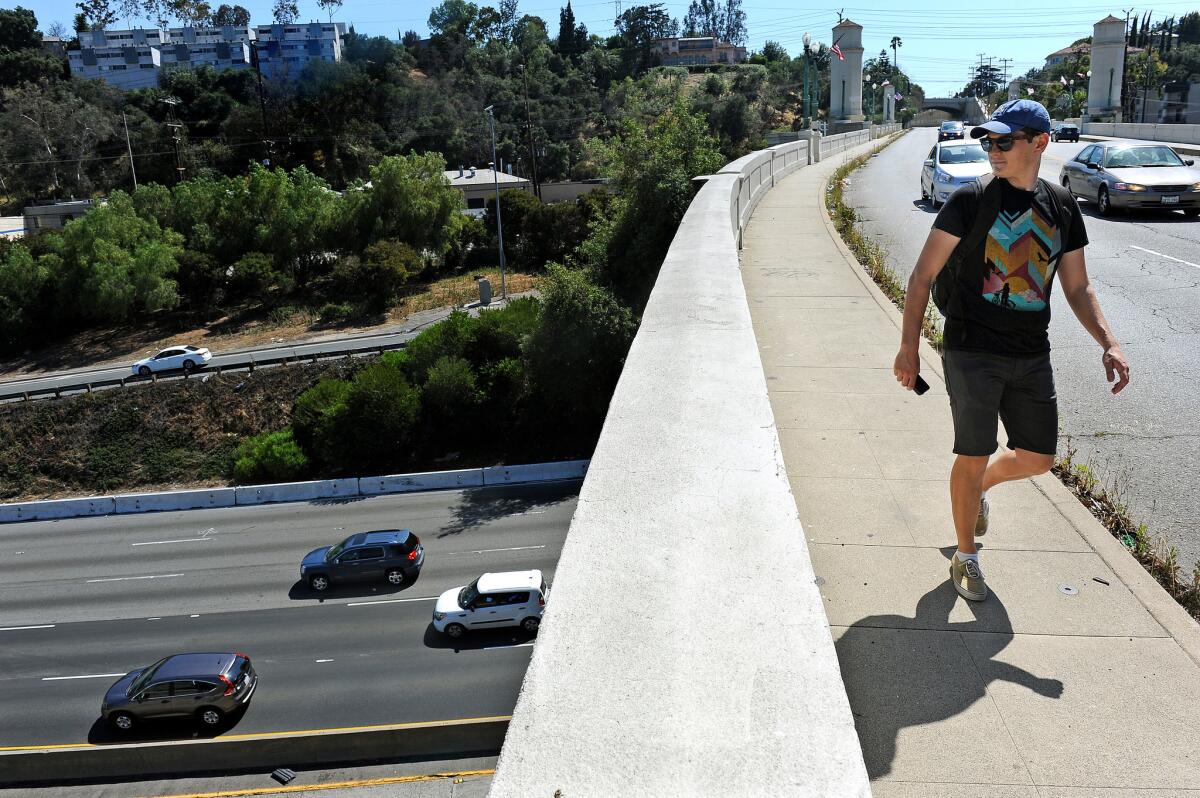 Niall Huffman walks along the Glendale-Hyperion bridge on June 7 while participating in a rally to keep sidewalks on both sides of the bridge as it undergoes retrofitting.