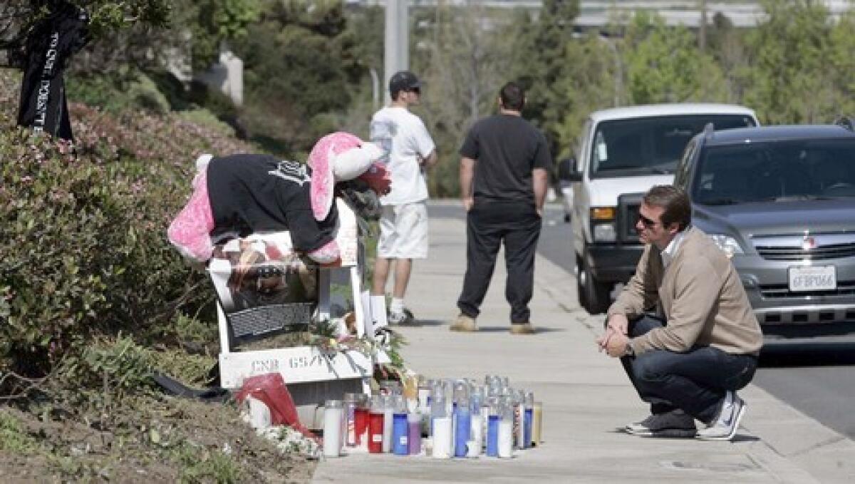 A man honors Charles Lewis at a roadside memorial. Lewis, a figure in the mixed martial arts scene, was killed when his Ferrari hit a light pole in Newport Beach.