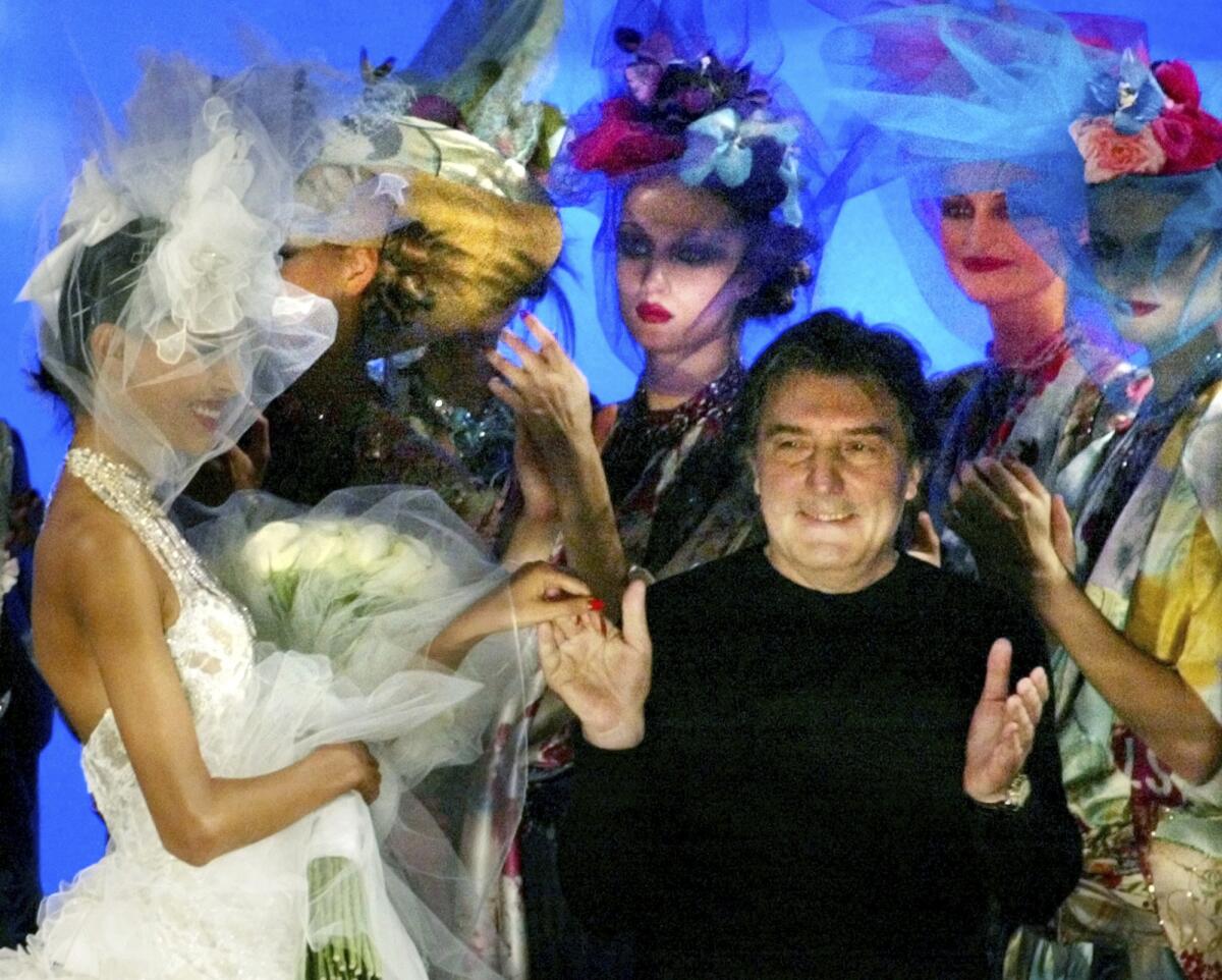 Emanuel Ungaro acknowledges applause at the end of a 2003 show in Paris.