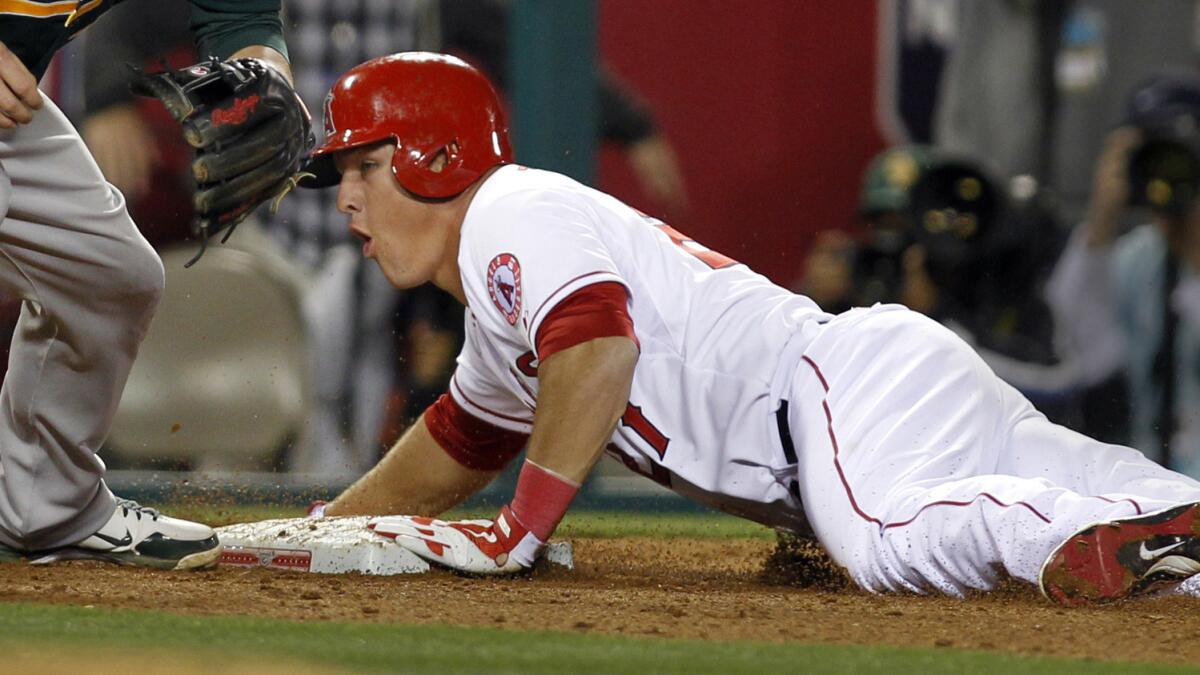 Angels outfielder Mike Trout slides safely into third base during a 2013 game against the Oakland Athletics. Trout says the Angels have not asked him to stop sliding head first.