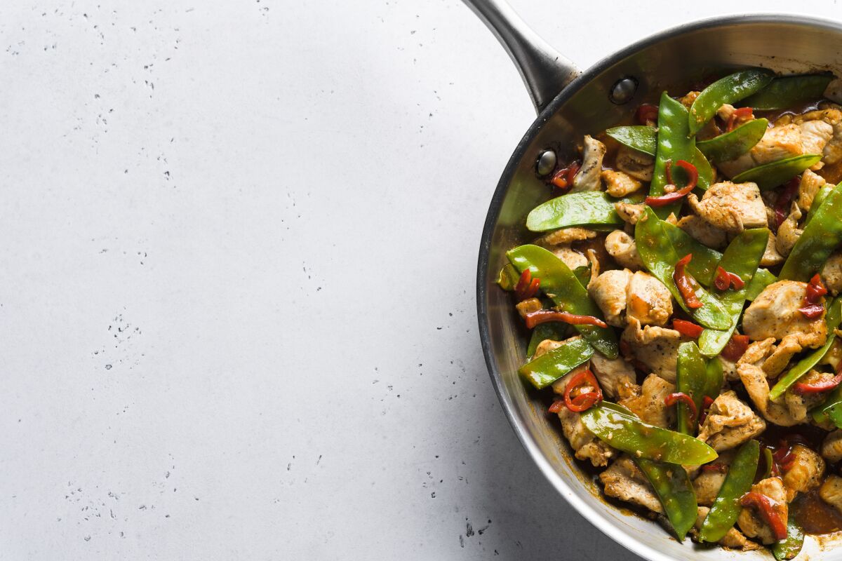 This image released by Milk Street shows a recipe for stir-fried chicken and snow peas. This recipe, with just six ingredients, was inspired by the popular Malaysian dish ayam paprik. (Milk Street via AP)