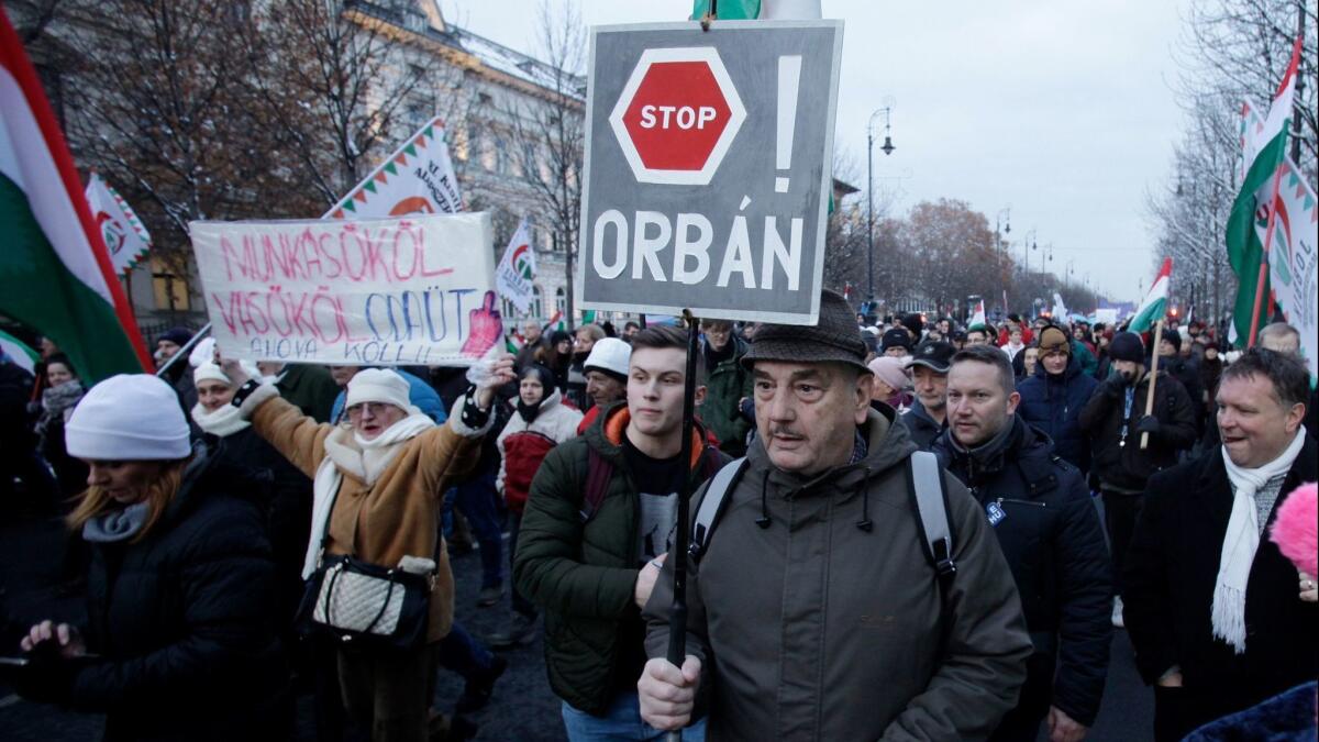 A protester holds a sign reading "Stop Orban" during a Dec. 16, 2018, march in Budapest to protest against changes to Hungary's labor code proposed by Prime Minister Viktor Orban's party.