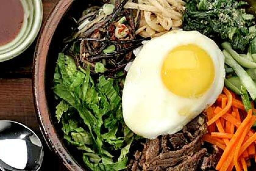 LOOKING SUNNY: Bibimbap with spinach, cucumber, carrots, beef, romaine, fernbrake and bellflower root, topped with a fried egg.