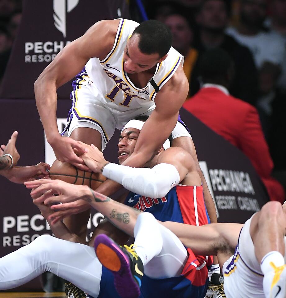 Lakers guard Avery Bradley, top, fouls Detroit Pistons guard Bruce Brown as center JaVale McGee, right, tries to steal the ball during the second quarter.