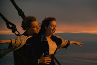A woman and a man stand on the bow of a ship