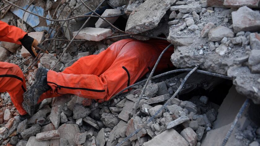 A member of the specialized rescue team known as Topos (moles) searches on Sept. 9 for survivors of this week's powerful earthquake in Juchitan de Zaragoa, Mexico, while hundreds of miles away Hurricane Katia struck the country's Gulf Coast.