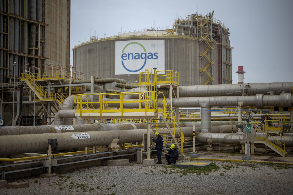 FILE - Operators work at the Enagss regasification plant, the largest LNG plant in Europe, in Barcelona, Spain, Tuesday, March 29, 2022. The European Union’s plan to reduce the bloc’s gas use by 15% to prepare for a potential cutoff by Russia this winter has been met with sharp skepticism by Spain and Portugal, two governments that are usually big supporters of the bloc. Madrid and Lisbon on Thursday, July 21, 2022 said they would not support the initiative announced by European Commission Ursula von der Leyen on Wednesday. (AP Photo/Emilio Morenatti, File)