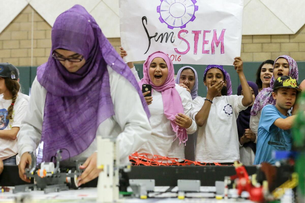 Team members cheer as their robot gets tested in competition.