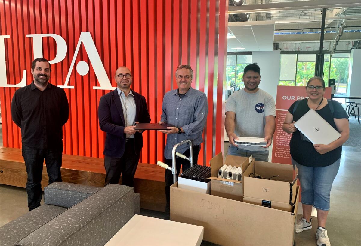 Orange Coast College Architecture Professor Rose Anne Kings, right, receives laptops donated to students by design firm LPA.