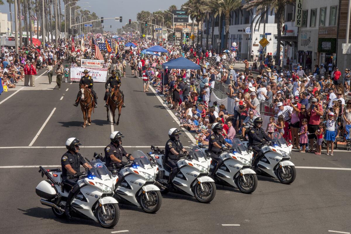 Huntington Beach motorcycle police lead the parade at PCH and Main Street during the 2022 Independence Day celebration.