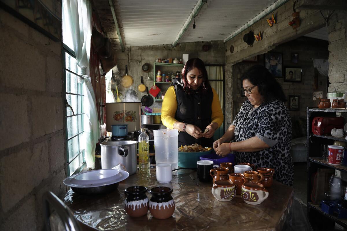 His daughter, Ivonne Nava Chavez, left, and wife Cecilia Rebeca Chavez prepare pozole for the family. (Katie Falkenberg / Los Angeles Times)