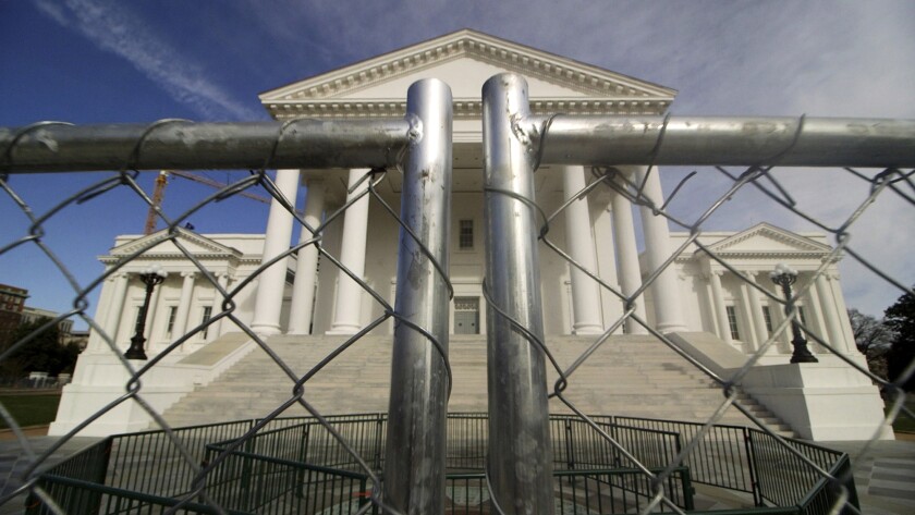 The Virginia state Capitol building surrounded by chain-link fencing.