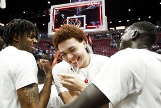 San Diego, CA - March 04: San Diego State's forward Elijah Saunders (25) holds a piece of the net in his mouth after the Aztecs' clinched Mountain West title at Viejas Arena on Saturday, March 4, 2023 in San Diego, CA. (Meg McLaughlin / The San Diego Union-Tribune)