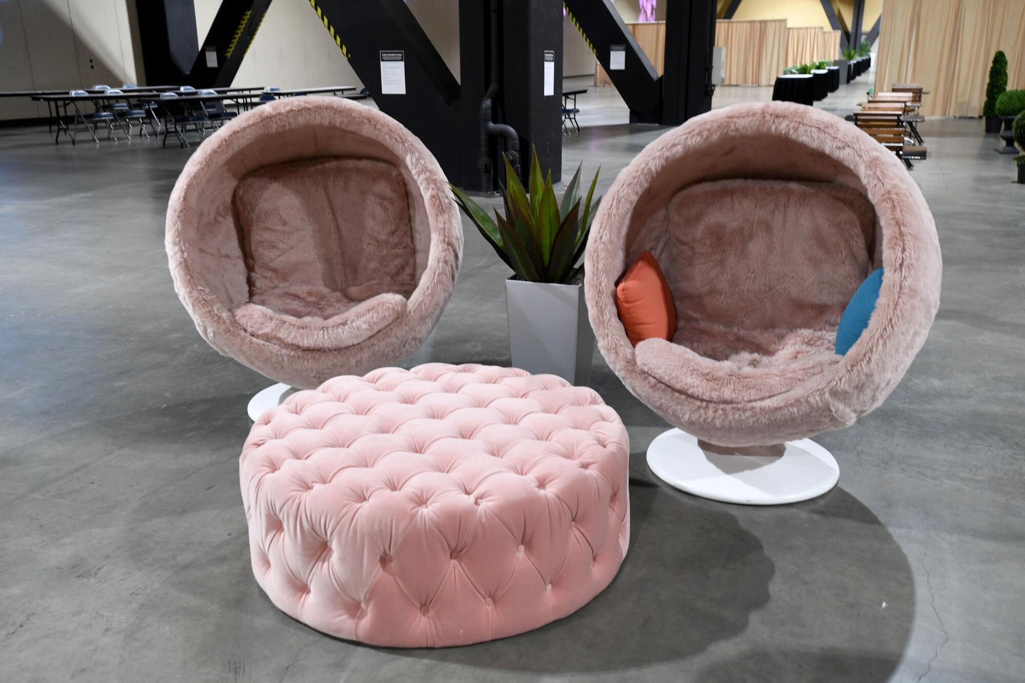 Pink nook-style chairs and an ottoman sit inside the convention center