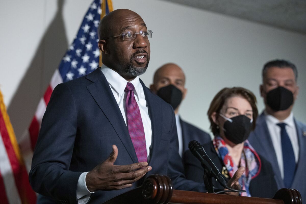 FILE - Sen. Raphael Warnock, D-Ga., speaks to reporters alongside Sen. Cory Booker, D-N.J., and Sen. Amy Klobuchar, D-Minn., and Sen. Alex Padilla, D-Calif., during a news conference at the Capitol in Washington, on Jan. 18, 2022. There's a shifting narrative on COVID-19 restrictions across the country among Democratic officials and candidates. They're increasingly supportive of easing mandates as they struggle to address voter frustration with the lingering pandemic. (AP Photo/Amanda Andrade-Rhoades, File)