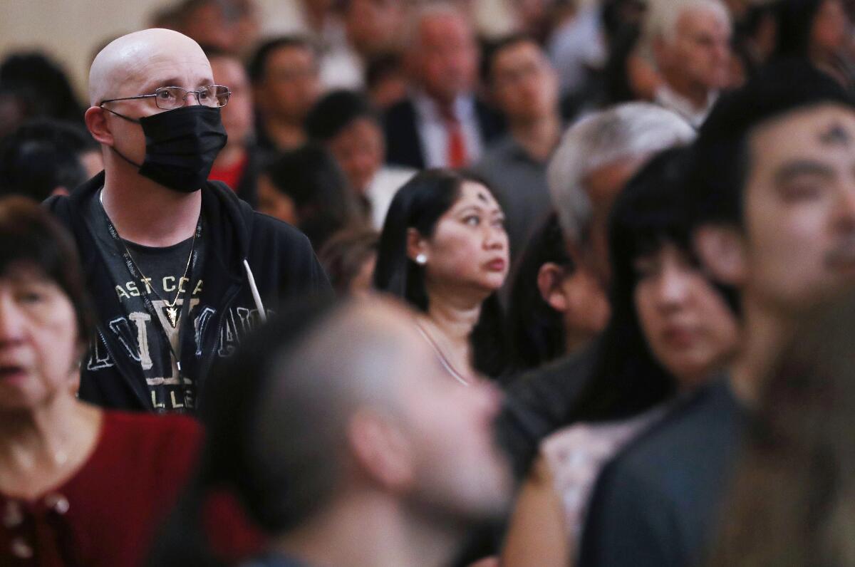 A worshiper wears a face mask during Ash Wednesday at the Cathedral of Our Lady of the Angels