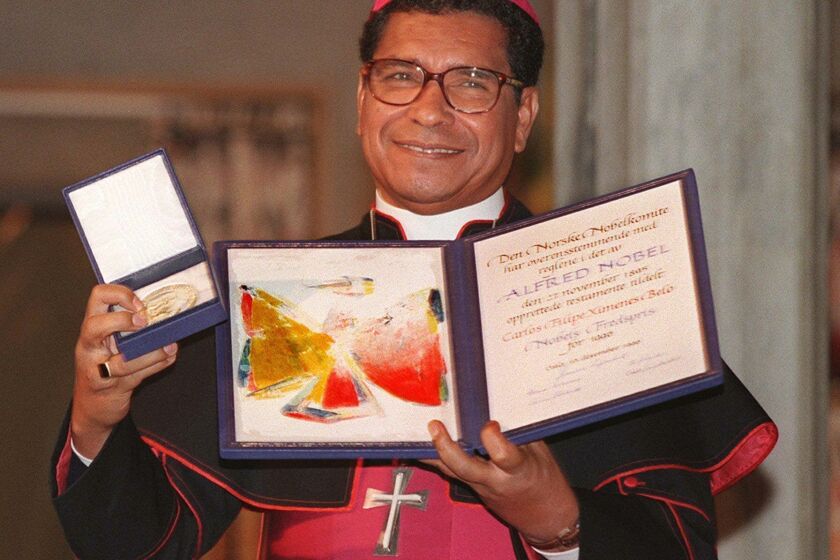 ARCHIVO - El obispo de Timor Oriental Carlos Filipe Ximenes Belo. ganador de un Nobel de la Paz, muestra su certificado y su medalla durante la ceremonia de entrega en el ayuntamiento de Oslo, el 10 de diciembre de 1996. (AP Foto/Bjoern Sigurdsoen, Archivo)