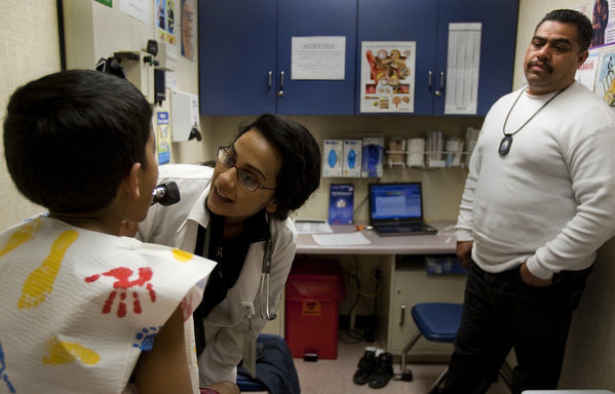 Nurse practitioner Sandeep Lehil examines Gael Farias, 6, while his father, Juan Farias watches during a routine physical at T.H.E. Clinic in Lennox. State lawmakers are considering a bill to expand the autonomy of nurse practitioners.