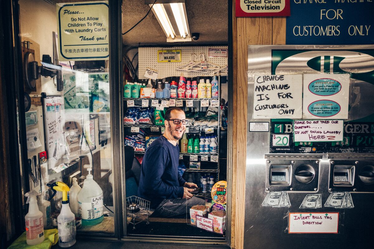 A man photographed inside the laundromat he owns.