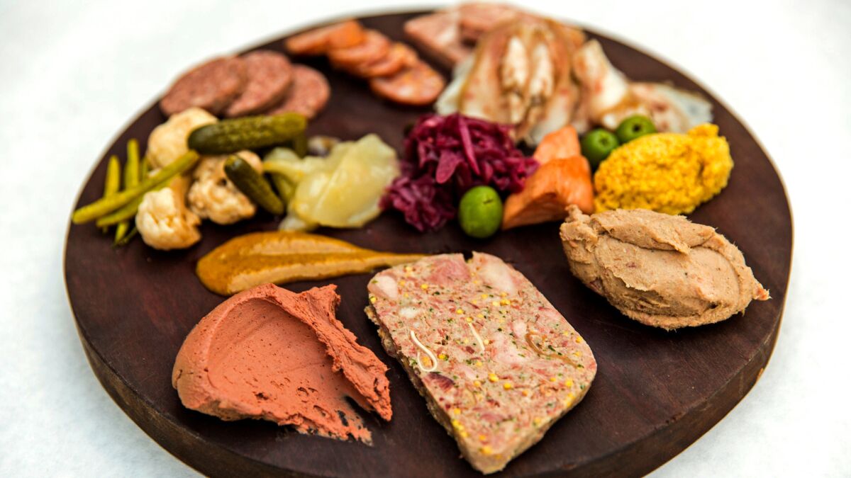 A plate of truffled chicken liver, terrine de campaign, rillettes, mustard, testa, liverwurst, andouille, smoked beef deckle, house pickles and olives at Terrine.