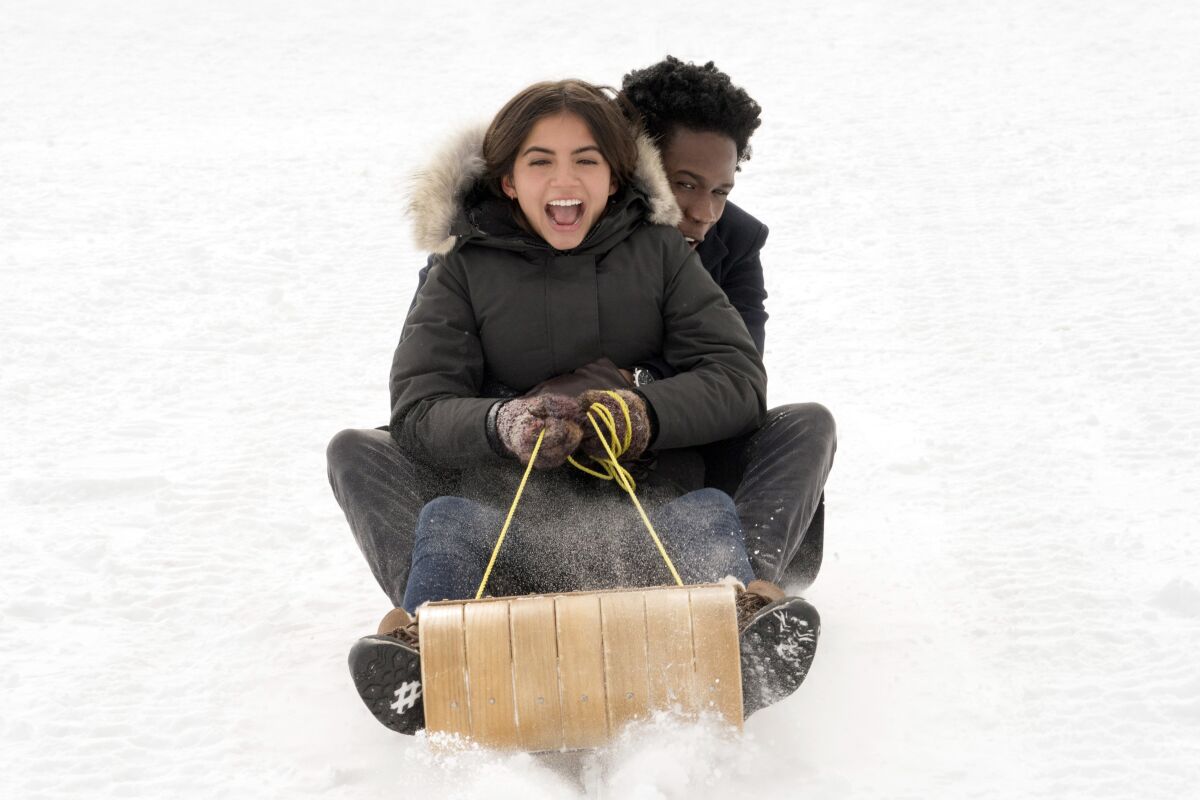 Isabela Merced and Shameik Moore on a toboggan in the movie 'Let It Snow'