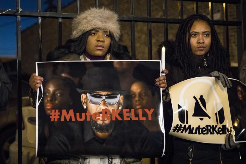FILE - #MuteRKelly supporters protest outside R. Kelly's studio, Wednesday, Jan. 9, 2019, in Chicago. Accusers and others demanding accountability for the R&B superstar over allegations that he was abusing young women and girls for decades say it took so long to get to a guilty verdict in part because his targets were Black. Kelly was convicted Monday, Sept. 27, 2021, in his sex trafficking trial. Those who work against sexual violence say Black women and girls who want to speak out face a society that hypersexualizes them from a young age. (Ashlee Rezin/Chicago Sun-Times via AP, File)
