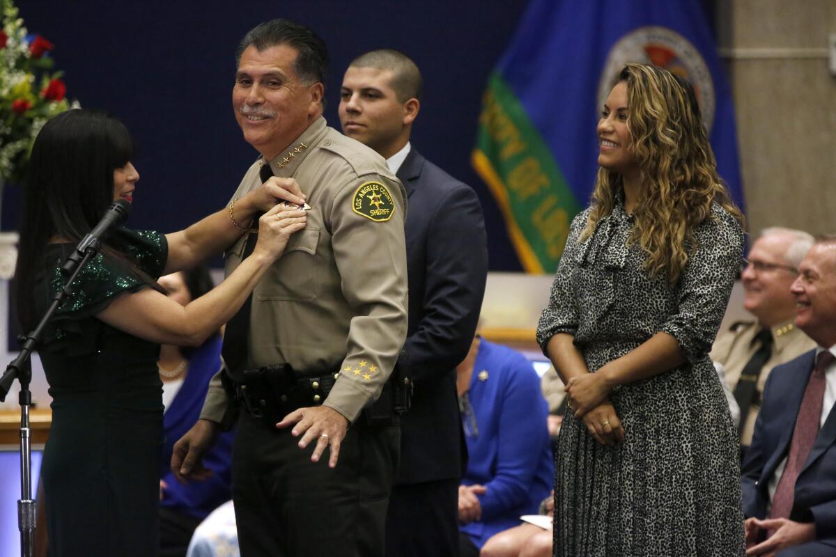 Robert Luna, surrounded by his family, is sworn in as sheriff.