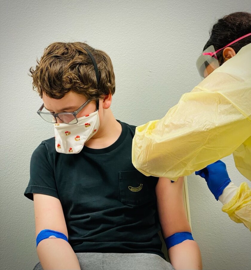 A teen boy receives an injection during a Moderna trial.