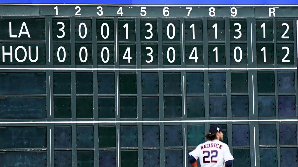 The Astros' Josh Reddick stands below a scoreboard showing the game tied 12-12. (Wally Skalij / Los Angeles Times)