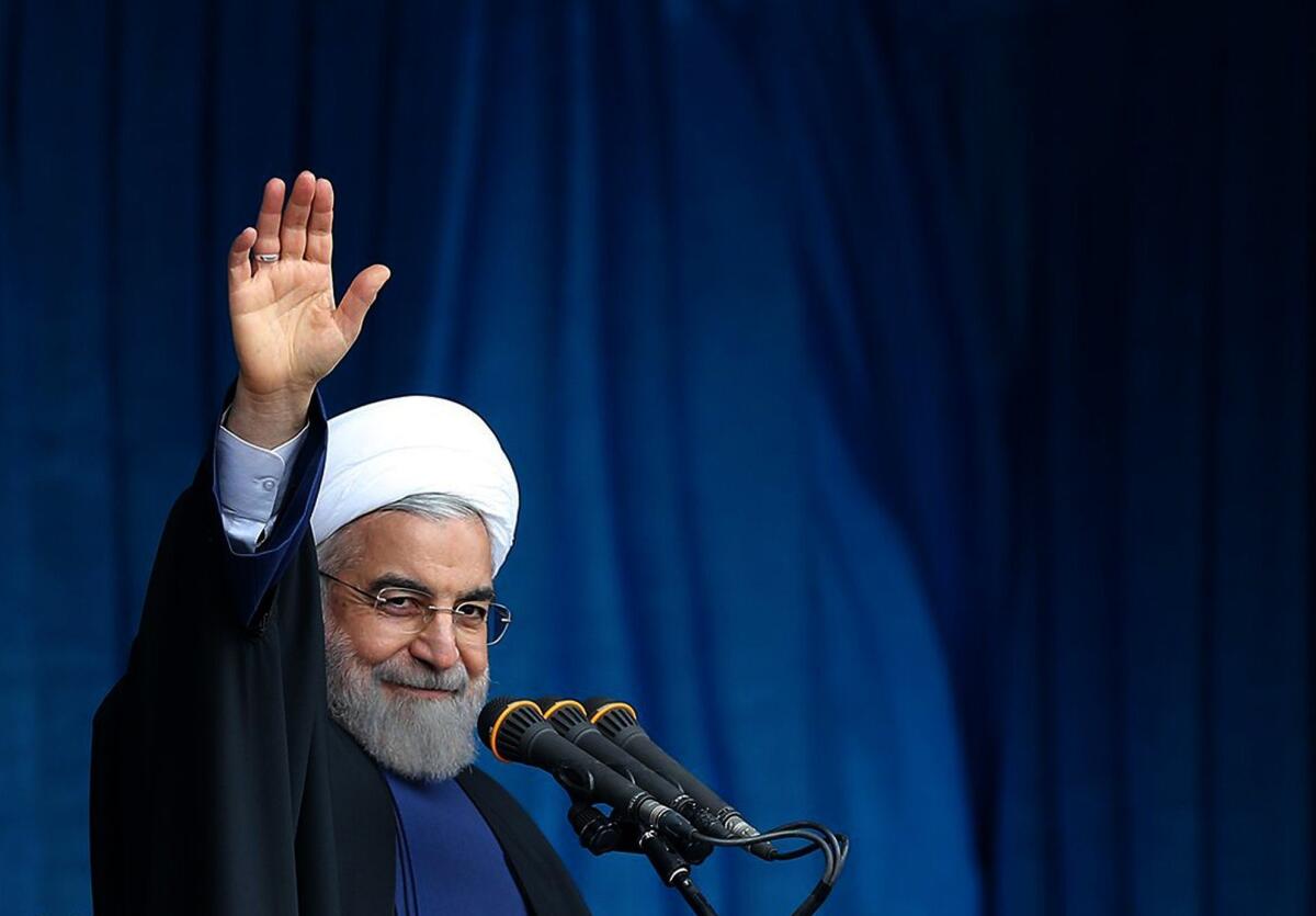A photo provided by the office of Iranian President Hassan Rouhani shows him waving to the crowd during a public speech.