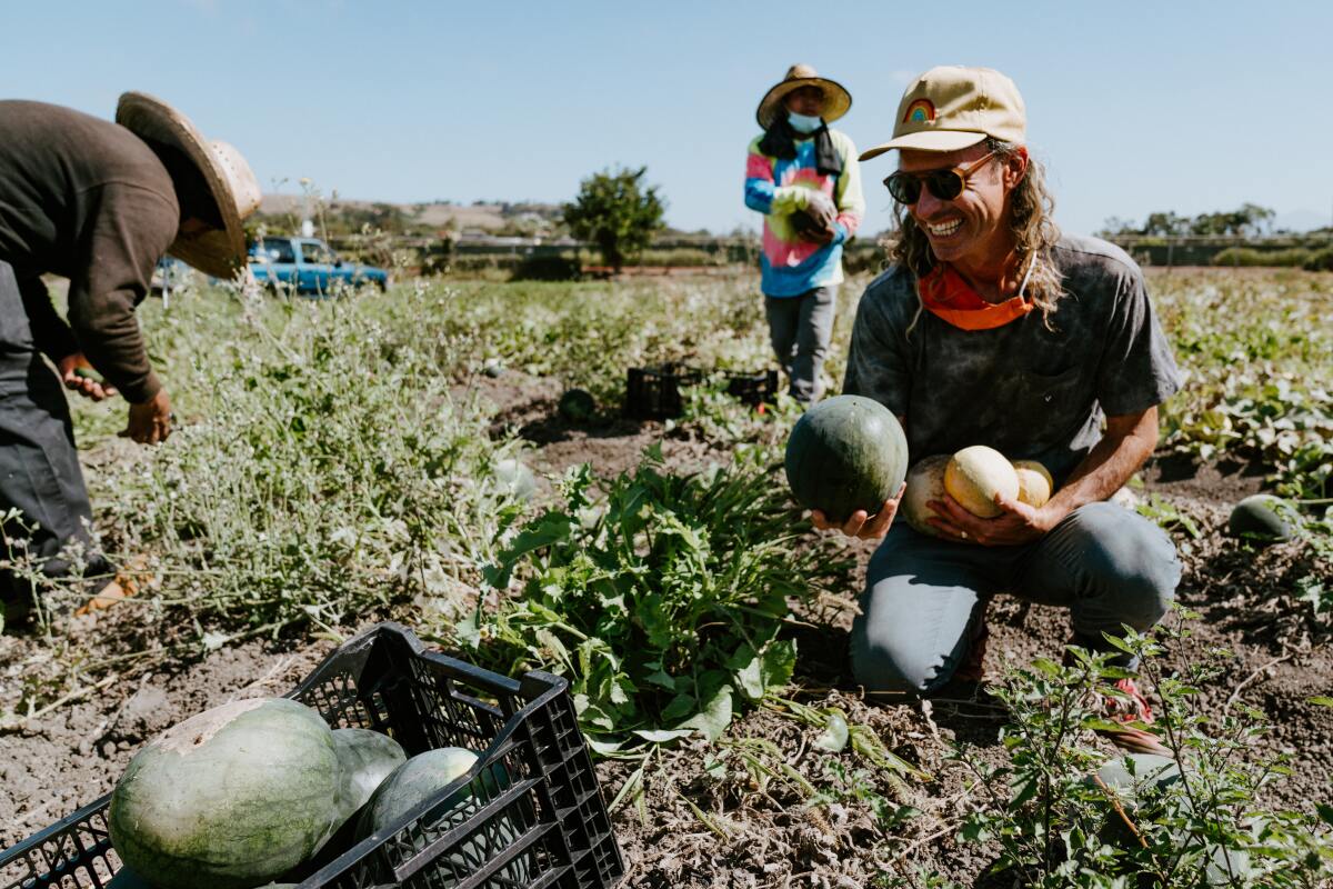 People in a field holding produce at the Ecology Center in San Juan Capistrano.